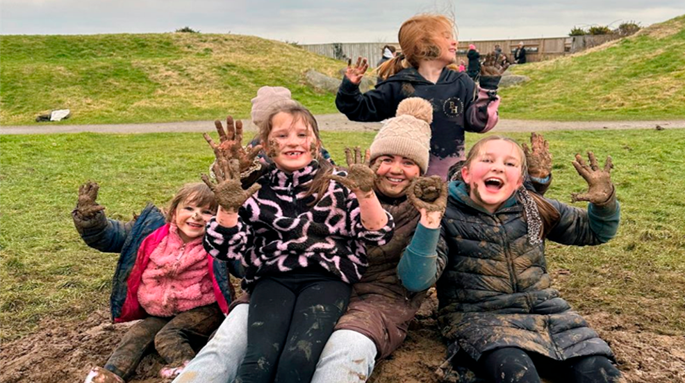 Children showing their muddy hands at WWT Mudfest